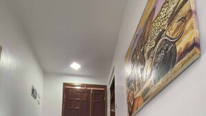 A staircase with a handrail, a door at the top, and a painting on the wall. - Cozy Studio Near City & Masaki (Dar es Salaam)