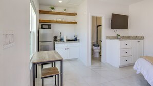 Una cocina moderna con armarios blancos, microondas integrado y encimera de madera.