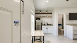 Eine moderne Küche mit weißen Schränken, einem Edelstahlkühlschrank und einem Holztisch.