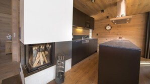 A modern kitchen with a built-in stove, wooden cabinets, and a large island with a sink. - Alpine Stay, Sauna & Fireplace (Bramberg am Wildkogel)
