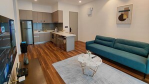 Un espacio habitable moderno con cocina, comedor y un sofá color turquesa.