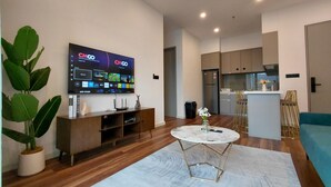 Una sala de estar moderna con un televisor de pantalla plana, una mesa de centro y una planta en maceta.