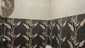 Un baño con inodoro, bidé y ducha.