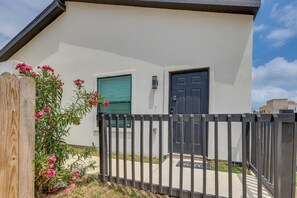 A building with a gated entrance, a door, and a window with shutters. - Walkable & Modern! South Padre Studio By Beach (South Padre Island)