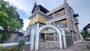 Un edificio tradicional con un arco de entrada destacado, un tejado de tejas y una fachada de piedra.