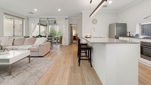 A modern living space with a kitchen, a dining area, and a sofa. - 3BR Comfortable Home (Edgewater)