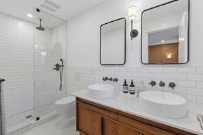 A modern bathroom with two sinks, a shower, and a toilet. - Charming Roncesvalles Home · High Park · BMO Field (Toronto)