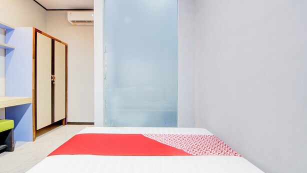 A hotel room with a bed, a wardrobe, a desk, and a chair.