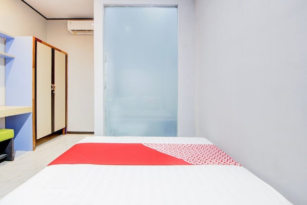 Una habitación de hotel con cama, armario, escritorio y silla.
