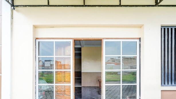 A building entrance with a set of glass doors and a small tiled area in front.