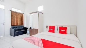 A hotel room with a bed, a sofa, a mirror, and a window. - Cozy Double Escape W/ Free WiFi and Parking (Yogyakarta)