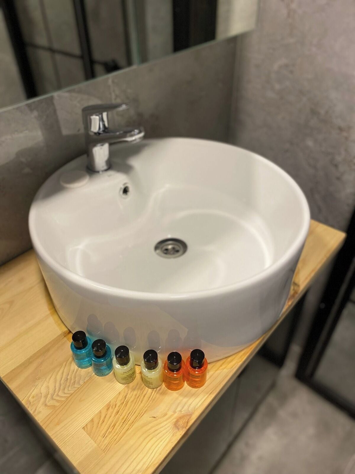 A white sink with a faucet on a wooden countertop.