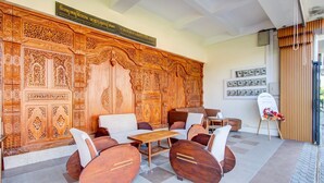 Un vestíbulo con un gran panel de madera, zona de estar y mostrador de recepción.