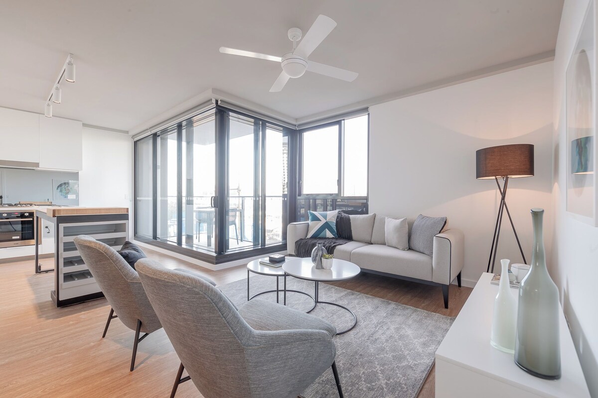 A modern living room with a sofa, chairs, a coffee table, and a floor lamp.