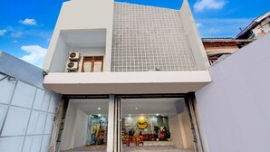 A modern building with a flat roof, large windows, and a visible entrance.