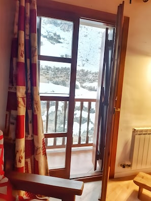 Une pièce avec une grande fenêtre, un banc en bois et un radiateur.