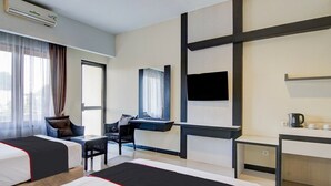 A hotel room with two beds, a desk, a chair, a TV, and a window with curtains. - Luxury Deluxe DBL Retreat W/ Free WiFi and Parking (Pekanbaru)