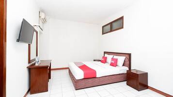 Een slaapkamer met een bed, nachtkastjes, een televisie en een raam.