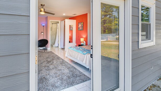 Ein Schlafzimmer mit Bett, Nachttisch, Lampe und Fenster.