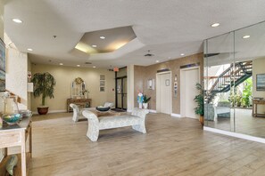 Eine Lobby mit einer Rezeption, einer Bank, einem Blumentopf und einer Treppe.