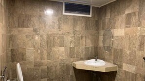 Un baño con inodoro, lavamanos y ducha.