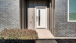 A modern building entrance with a brick facade, a door, and a small step leading to the entrance. - Work & Play! Gem w/ Fire Pit, 3 Mi to Dtwn Dallas (Dallas)