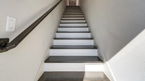 A staircase with wooden steps and a handrail, leading to a landing with a light switch. - Work & Play! Gem w/ Fire Pit, 3 Mi to Dtwn Dallas (Dallas)