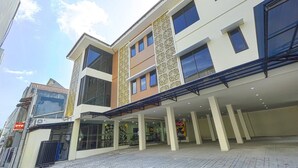 A multi-story building with a covered entrance area, large windows, and a tiled ground floor. - Luxury Twin Stay with Free WiFi and Parking (Yogyakarta)