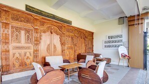 Un vestíbulo con un amplio panel de madera en la pared, una zona de estar con mesa y un tablero de exhibición con fotografías.