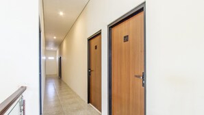 Un pasillo con dos puertas de madera, cada una con un número.