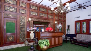 A reception area with a wooden reception desk, a chandelier, a sofa, and a large potted plant. - Luxury Deluxe DBL Retreat W/ Free WiFi and Parking (Solo)