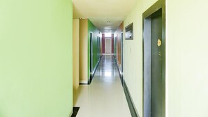 Un pasillo largo y estrecho con puertas a ambos lados que dan a habitaciones individuales.