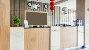 A reception desk with a clock, a potted plant, and a sign. - Luxury Twin Stay with Free WiFi and Parking (Palembang)
