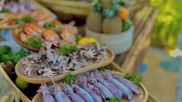 A seafood display with various dishes, including squid and shrimp, arranged on wooden platters.