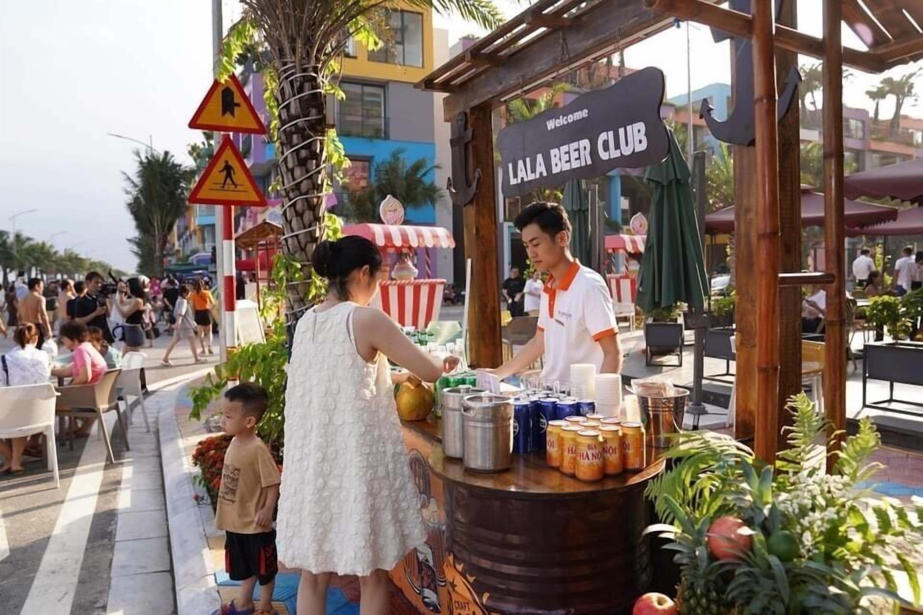Ein Imbissstand mit einem Schild mit der Aufschrift 'LALA BEER CLUB' und einem einladenden Schild darüber.