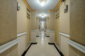 A hallway with a tiled floor, white walls, and a ceiling with a light fixture. - Cozy Double Escape W/ Free WiFi and Parking (Padang)