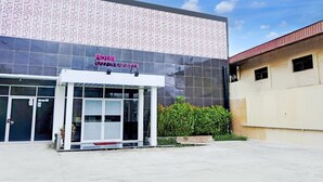A hotel with a modern facade, large glass windows, and a sign indicating it is a hotel. - Luxury Deluxe Double Retreat with Parking Access (Padang)