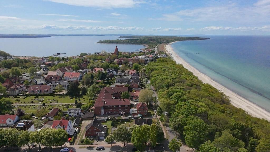 A coastal town with houses, a church, and a beach.