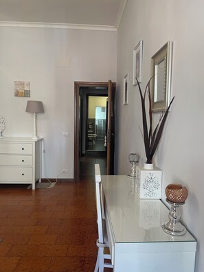 Ein modernes Wohnzimmer mit einem Glastisch, weißen Möbeln und dekorativen Accessoires.