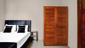 A bedroom with a bed, a wooden wardrobe, and a nightstand. - Luxury Deluxe DBL Retreat W/ Free WiFi and Parking (Surabaya)
