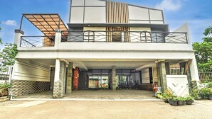 A modern two-story building with a flat roof, large windows, and a covered entrance. - Luxury Deluxe DBL Retreat W/ Free WiFi and Parking (Surabaya)