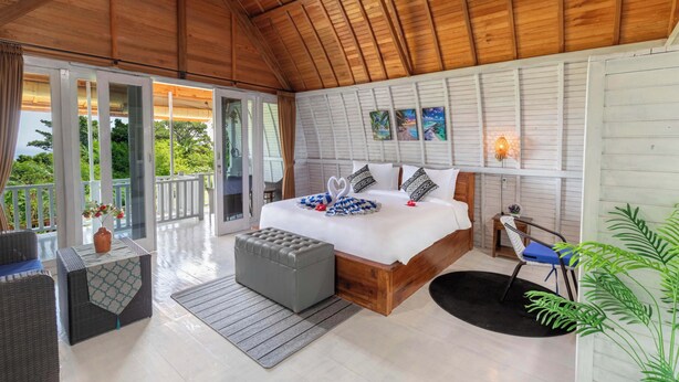 A bedroom with a large bed, a wooden ceiling, a balcony, and a view of greenery. - Nusa Sunshine Private Villa Ceningan (Ceningan Island)