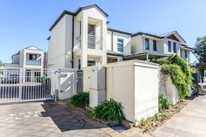 A modern residential building with a gated entrance, a balcony, and a small garden area. - Brighton 3BR Townhouse |Sauna |Walk to Jetty,Train (Brighton)