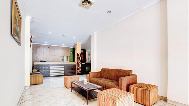 Una sala moderna con un sofá, pufs y una mesa de centro.