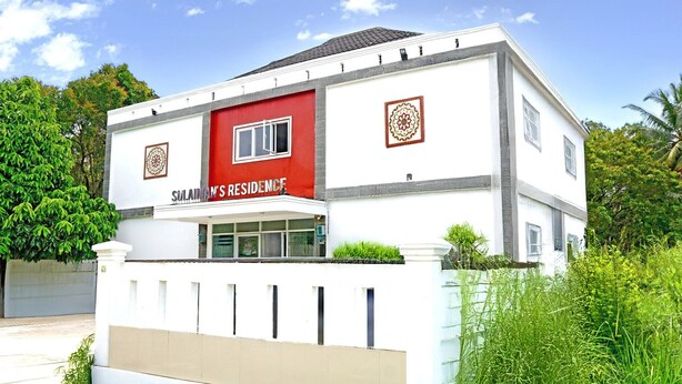 A two-story building with a red and white facade, a sign reading 'SULAIN'S RESIDENCE,' and a gated entrance. - Luxury Deluxe DBL Retreat W/ Free WiFi and Parking (Padang)