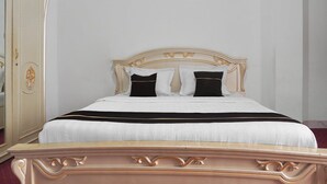 Una cama con cabecera, mesita de noche y armario.