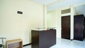 A reception desk with a glass top, a wooden bench, and a dark-colored reception area.