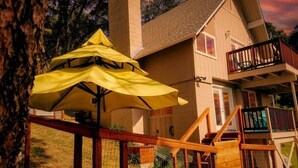A house with a wooden deck, a staircase, and a yellow umbrella. - Yosemite, River falls Retreat — Bass Lake (Oakhurst)