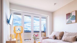 Ein modernes Wohnzimmer mit einer Couch, einer dekorativen Lampe und einem Gemälde an der Wand.