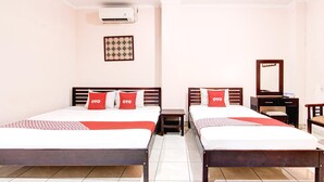 A hotel room with two beds, a small bedside table, a mirror, and a wall-mounted air conditioner. - Family Luxury Suite W/Free WiFi and Parking (Semarang)